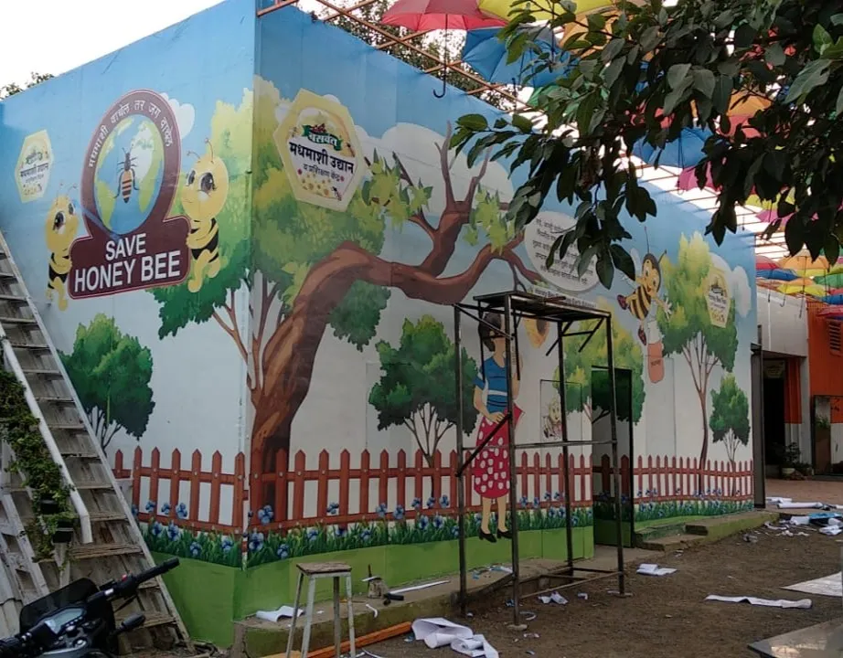 Painted mural of trees and a honey bee on a park wall